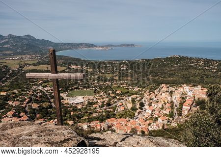 View Over The Village Of Lumio And The Bay Of Calvi And Revellata From A Wooden Cross In The Balagne