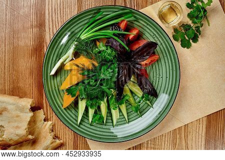 Assorted Sliced Vegetables With Fresh Greens On Platter With Shotis Puri And Chacha