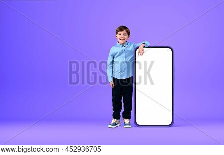 Boy Kid Smiling, Standing Full Length Hand Lying On Smartphone Mock Up Blank Screen, Purple Backgrou
