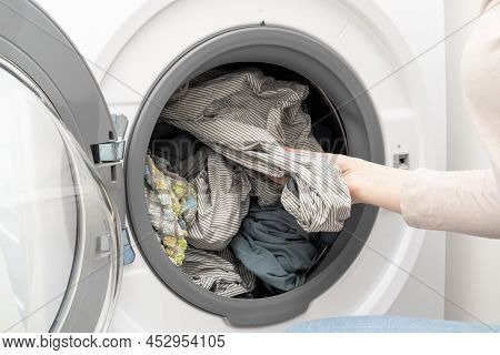 Washing Machine With Clean Laundry. Woman Hand Pulling Out Washed Bed Linen From Drum Of Washing Mac