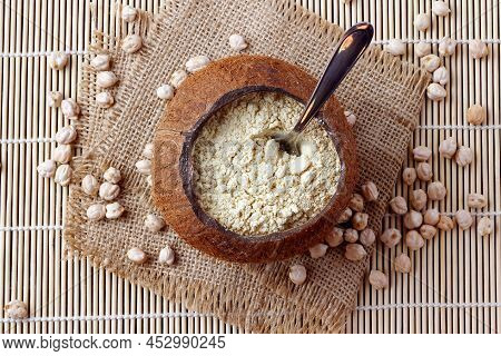 Organic Chickpea Flour In Bowl Over Rustic Wooden Table. Gluten Free