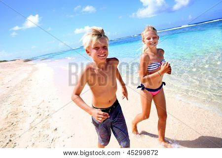 孩子们在加勒比的沙质海滩上运行