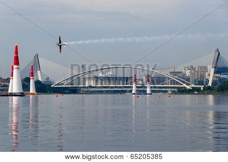 PUTRAJAYA, MALAYSIA - MAY 17, 2014: Nicolas Ivanoff of France in an Edge 540 V2 plane flies across the lake in Putrajaya at the qualifying session of the Red Bull Air Race World Championship 2014.
