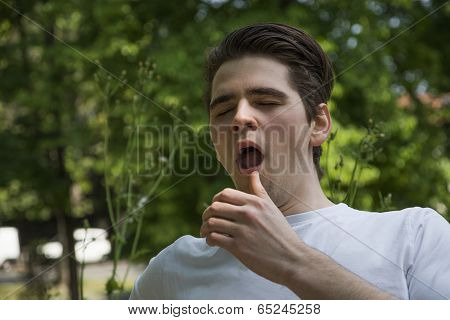 Allergic Young Man Sneezing In Park