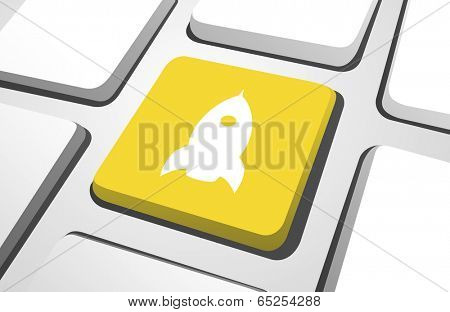 Close-up of yellow rocket computer icon on a keyboard button.