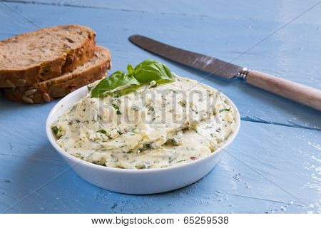 Herb Butter In A Bowl On Blue Wood