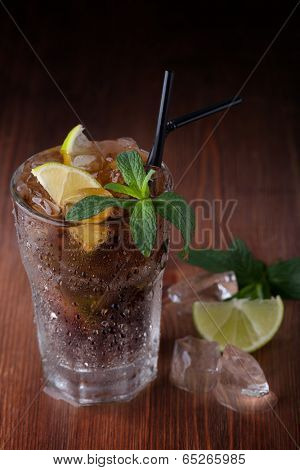 Cuba Libre Drink with lime on a wooden table