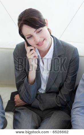 Uśmiechnięta kobieta na telefon czekając na rozmowę o pracę