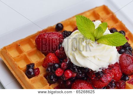 a selection of three italian gelato ice-cream scoops topped with nuts, chocolate, fruit served on crispy waffels