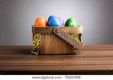 Basket, Colored Easter Eggs On Table, Gray Background