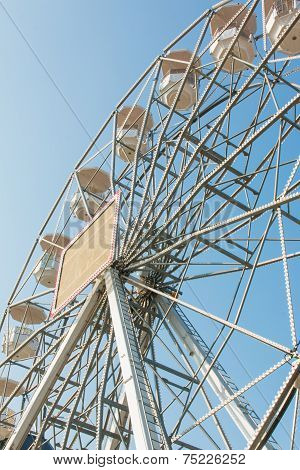 White Ferris Wheel Against Blue Sky Background