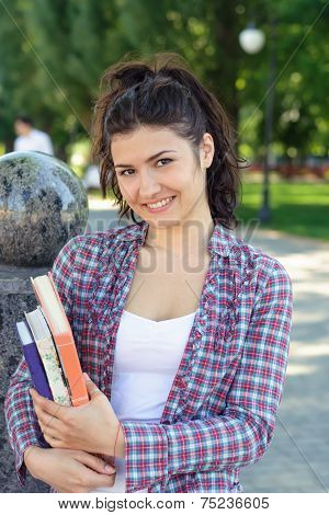 Girl Student Holding A Book In Her Hands.