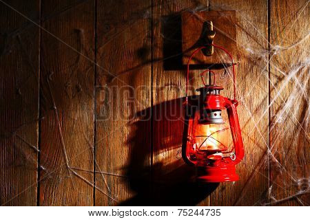 Lantern hanging on hook on wooden wall