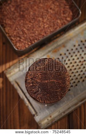 roasted cocoa beans in Vintage heavy cast aluminum roasting pan and and 100% solid chocolate on wood background