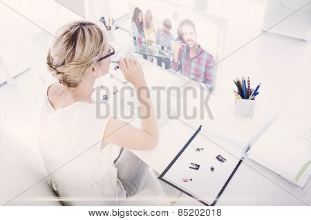 Composite image of female photo editor working on computer