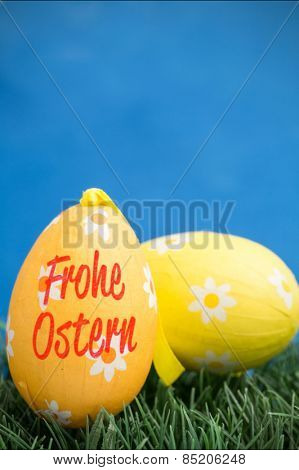 frohe ostern against two easter eggs on grass