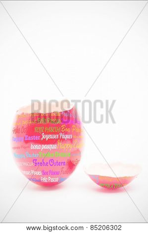 Happy easter in different languages against red painted egg with top broken off