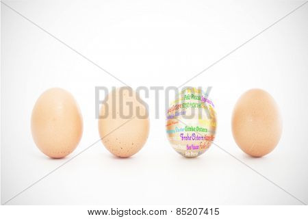 Happy easter in different languages against four eggs in a row with one gold one