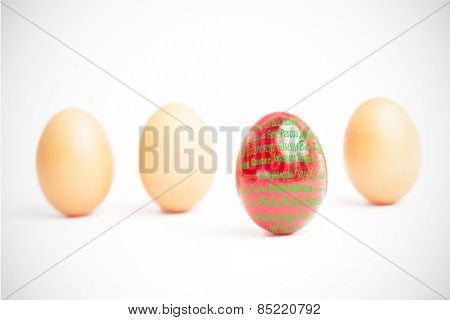 Happy easter in different languages against four eggs in a row with one red one standing out