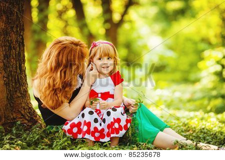 Mother and her little daughter on a walk in the park in the summer.