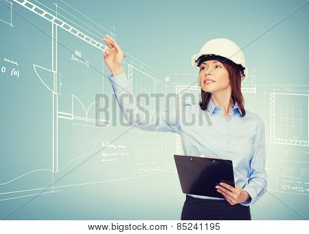 building, developing, consrtuction and architecture concept - smiling businesswoman in white helmet with clipboard pointing finger