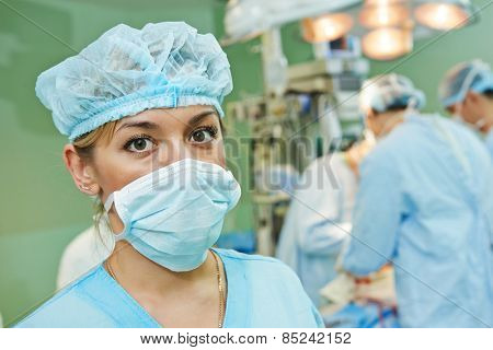 surgeon assistant nurse in uniform during heart transplantation operation on a patient at cardiac surgery clinic