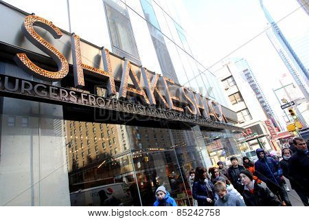 NEW YORK CITY - FEB. 25, 2015:  Pedestrians walk past a Shake Shack restaurant. Shake Shack is a fast casual restaurant chain based in New York City

