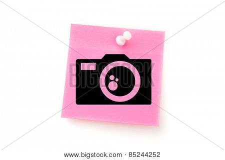 Camera against pink adhesive note with pushpin