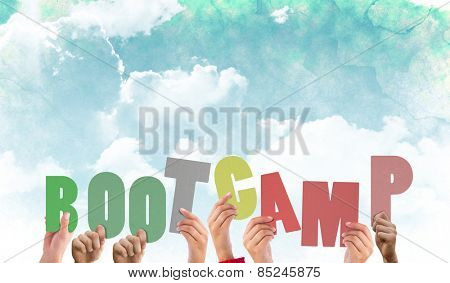 Hands holding up boot camp against green and blue sky
