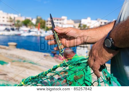 Majorca Cala Ratjada beach Rajada fisherman sewing fishing net