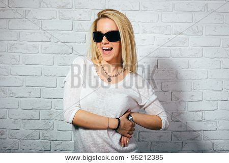 Beautiful blonde girl in branded sunglasses smiling