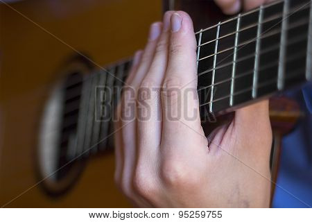 Acoustic Guitar's Fretboard And Young Male's Hands