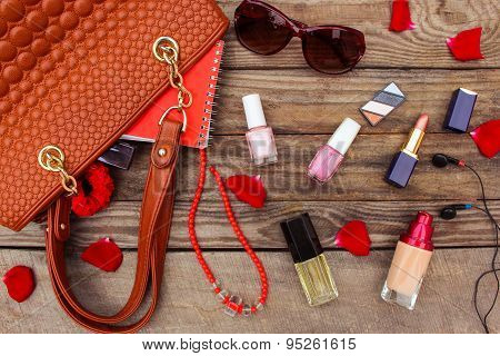 Things from open lady handbag. women's purse on wood background. Toned image.