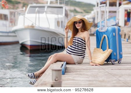 Pregnant beautiful woman on the pier at the sea