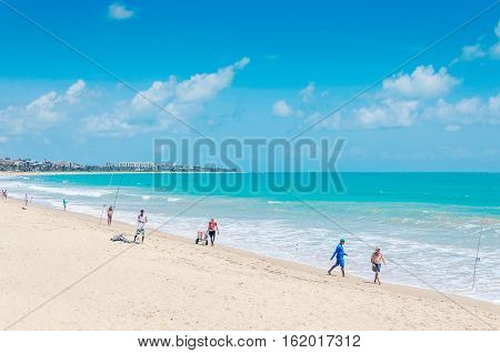 Joao Pessoa PB Brazil - December 8 2016: Beach of Joao Pessoa city with sand bay and a beautiful blue water ocean. People fishing by the sea on a sunny day. Holiday destination.