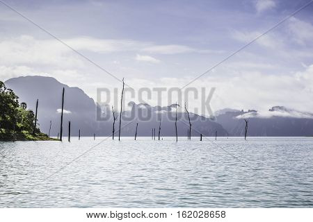 Silhouette at sunrise Mountain silhouette view with sky cloud fog and water surface at ratchaprapa dam Suratthani Thailand.