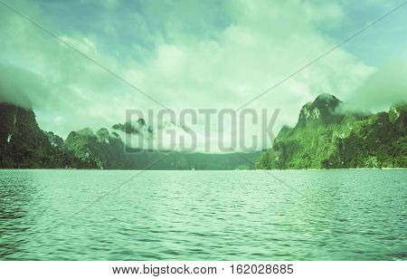 Silhouette at sunrise Mountain silhouette view with sky cloud fog and water surface at ratchaprapa dam Suratthani Thailand.