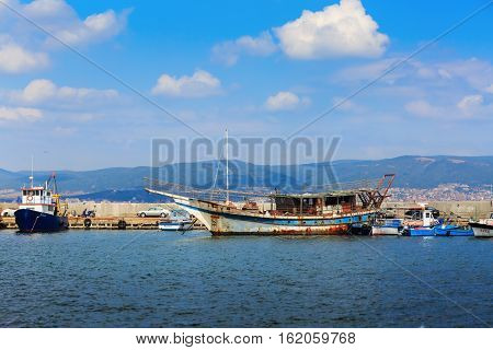 Nesebar Bulgaria - August 30 2013: Old ship boats yachts and launches standing at the pier in the port of the old town of Nessebar on the Black Sea coast. Sunny summer day.