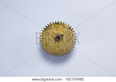 old bronze gear with scratches and corrosion on a white background