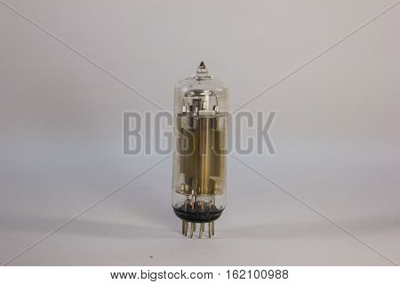 old glass vacuum tube with metal parts inside on a white background