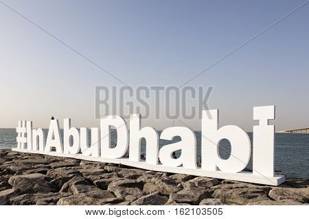 ABU DHABI - NOV 26 2016: #InAbuDhabi twitter hashtag sculpture at the corniche. Abu Dhabi United Arab Emirates