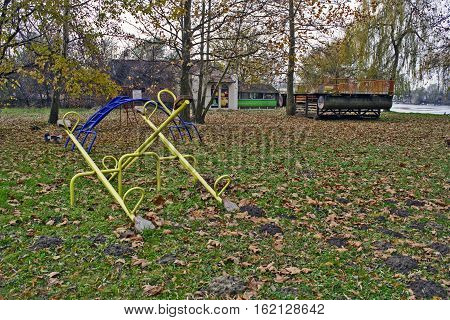 An empty playground on the bank of the river in autumn.