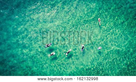 Surfers rest on the surface of the ocean