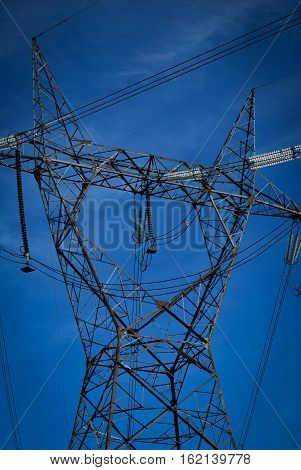 High voltage electricity cables datail over a clean blue sky