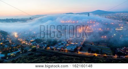 Early morning fog over the rising city of Queretaro Mexico. The aqueduct of Queretaro, is currently building a monumental seventy four arches reaching an average height of twenty eight meters.