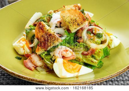 Korean salad with egg and seafood in green dish