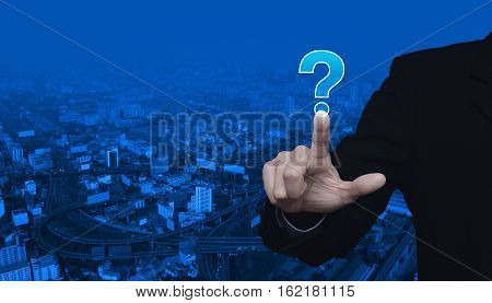 Businessman pressing question mark sign icon over city tower and street blue tone background Customer support concept