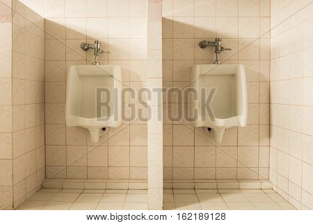 Closeup tiles wall in the toilet of man with toilet view by urinals
