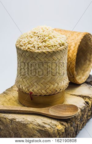 Brown rice in the kratip rice and on wood block.