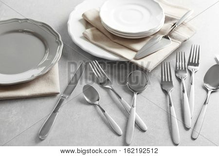 Cutlery set with plates on gray table